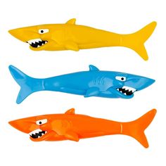 three plastic shark toys with teeth on them, one is orange and one is blue