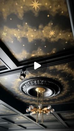 a ceiling with stars painted on it and a chandelier hanging from the ceiling