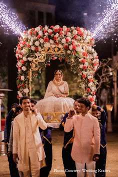 the bride and groom are surrounded by their children as fireworks go off in the background