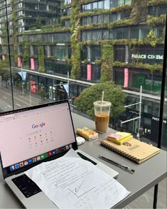 an open laptop computer sitting on top of a desk next to a cup of coffee