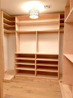 an empty walk in closet with wooden shelves