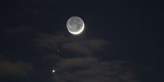 the moon and venus are visible in the night sky above some clouds on a dark, dreary day