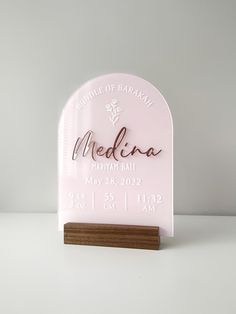 a pink plaque with the name and date on it that says meduna in cursive writing