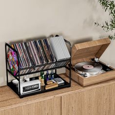 a record player sitting on top of a wooden dresser next to a shelf filled with cds