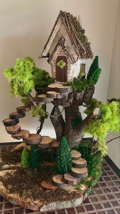 a miniature tree house made out of wood logs and trees with moss growing on them