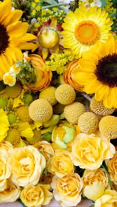 yellow flowers and sunflowers are arranged together