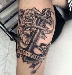 an anchor and rose tattoo on the arm