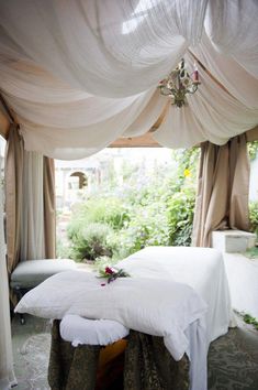 a white bed sitting under a canopy in a bedroom