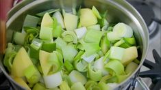 green onions and celery are being cooked in a pot on the stove top