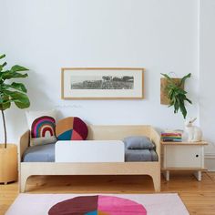 a living room with white walls and wooden floors, colorful rugs on the floor