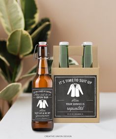 a bottle of beer next to a cardboard box with labels on it and a plant in the background