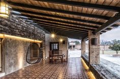 an outdoor dining area is lit up with lights and stone walls, along with brick flooring