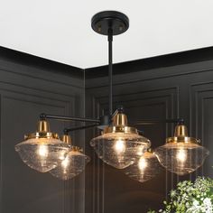 This 5-light chandelier is the perfect addition to any home looking to add a touch of sophistication and modern style. The combination of matte black and brass plating makes for a stunning black gold chandelier that can easily match with contemporary, modern farmhouse, mid-century modern, transitional, and traditional style home decor. The geometric shape of the chandelier is a standout feature that adds to its overall modern design. The schoolhouse-inspired seeded glass shades diffuse light in Cabin Chandelier Dining Room, Mid Century Hanging Light, Chandelier For Small Dining Room, Moody Chandelier, Dining Room Light Fixtures Low Ceiling, Design Vignettes, Dinning Room Light Fixture, Black And Brass Chandelier, Black And Gold Chandelier