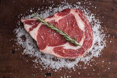 raw meat with rosemary sprig on top of it