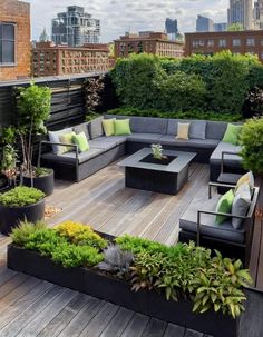 an outdoor living area with couches, tables and potted plants on the deck