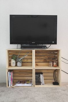 a flat screen tv sitting on top of a wooden shelf