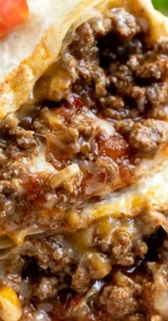 a close up of food on a plate with tomatoes and meat in the background,