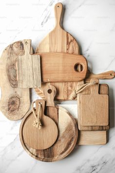 several wooden cutting boards and knives on a marble surface