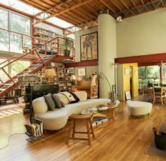 a living room filled with furniture and a fire place next to a stair case on the wall