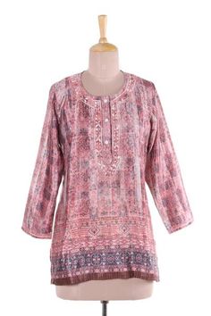 In hues of petal pink and linen intricate vines and floral motifs are printed onto this tunic from India. Shalabh designs this lovely tunic which features floral motifs around the button-up neckline that are hand-embroidered from cotton. Traditional Pink Floral Print Kurta, Spring Floral Print Straight Kurta Blouse, Festive Floral Print Tunic, Spring Pink Blouse With Printed Motifs, Floral Print Straight Kurta Blouse For Spring, Pink Printed Blouse For Spring, Pink Straight Kurta With Floral Print, Traditional Pink Kurta With Floral Print, Summer Pink Floral Print Kurta