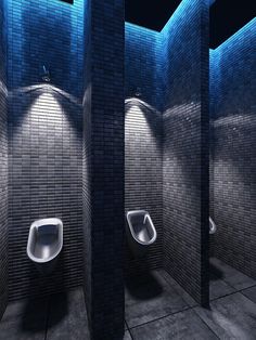 three urinals in a public restroom with blue lighting