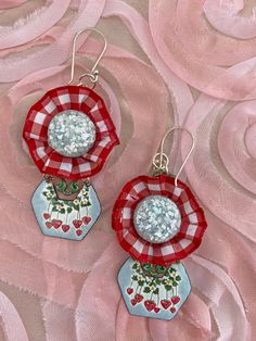 These earrings are chic and fun to wear.  So unique in design and components.  The top portion of these dangles have red and white small print ribbon encasing up-cycled vintage light blue cabs from a vintage set of earrings.  The cabs are so 50's with all the glitter type materials in them.  This is attached to a metal finding that has been painted a dark green.   The lower dangle portion are hand enameled metal with a strawberry motif.  If you follow me at all then you know I adore strawberry jewelry!   The 2 pieces together have great movement when worn and feel so stylish on.   The ear wires and jump rings are silver tone. These will arrive nicely packaged and ready for gift giving if desired.  Measurements: Length is 2-1/2" long, not including the ear wire portion.   Width is 1-1/2" at Red Enamel Earrings For Party, Playful Red Dangle Jewelry, Playful Red Drop Earrings, Fun Red Round Jewelry, Whimsical Handmade Red Earrings, Playful Red Nickel-free Jewelry, Whimsical Red Jewelry For Valentine's Day, Whimsical Red Party Jewelry, Playful Nickel-free Red Earrings