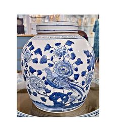 a blue and white vase sitting on top of a glass table