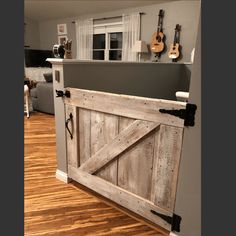 a room with a wooden door and guitars on the wall