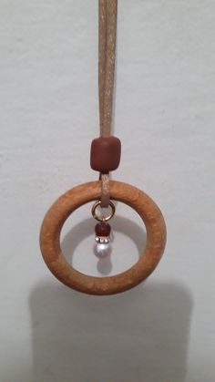 a wooden ring with a bead hanging from it