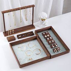 three wooden boxes with jewelry in them sitting on a table next to a white bust