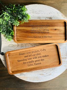 two wooden trays sitting on top of a white plate with words written on them