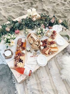 a picnic on the beach with food and drinks laid out for people to enjoy it