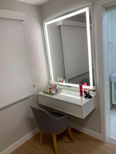 a bathroom with a chair, vanity mirror and lights on the side walk in front of it