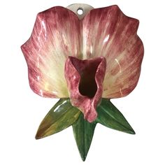 a pink and white flower hanging from a hook