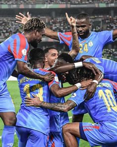 a group of men standing on top of a soccer field