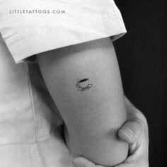 a woman's arm with a small coffee cup tattoo on the left inner forearm