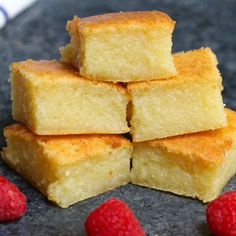 several pieces of cake and raspberries on a table