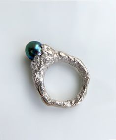 This Tahitian Black Pearl Mountain Ring is a nature-inspired piece of jewelry that resembles a majestic mountain. Its overall shape features an irregular texture, reminiscent of natural formations. Nestled in the center is a precious iridescent Tahitian pearl. This ring exudes a cool and gender-neutral style. This is a ready-to-ship item! -Gems Information Tahitian black pearl This pearl itself showcases a stunning color with high saturation and excellent luster. Its vibrant hue is a captivating blend of blue and green, while the ring's centerpiece emits a radiant halo of red light. -Size US 7, 25 can be sized, please contact me for more informations -Materials 925 silver -Packaging Your ring will arrive in a beautiful surprise gift box. Customization We offer the option to customize this Sea Inspired Jewellery, Irregular Rings, Sea Inspired Jewelry, Black Pearl Ring, Radiant Halo, Half Bezel Setting, Mountain Ring, Half Bezel, Single Pearl