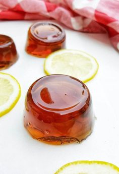 honey and lemon slices on a white surface with red and white checkered table cloth