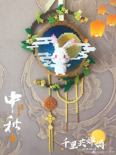 an image of a clock made out of string and beads with paper lanterns in the background