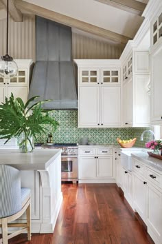 a large kitchen with white cabinets and wood flooring is seen in this image from the front view