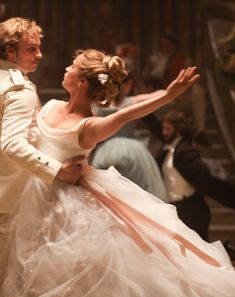 a man in a tuxedo and a woman in a wedding dress are dancing