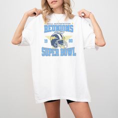 Get ready to cheer for your favorite reality TV stars with our Real Housewives Super Bowl T-Shirt - the ultimate Bravo merch for fans of the Real Housewives series! This vintage football style t-shirt is perfect for showing off your love for the drama, the glamour, and the unforgettable reunions of your favorite housewives. Key Features: Premium Comfort Colors 1717 T-Shirt: Made from 100% ring-spun US cotton, this Comfort Colors 1717 tee is renowned for its super-soft, garment-dyed fabric, ensur White Sports Fan T-shirt For Fan Events, White Sports Team Tops For Fan Events, White Tops With Team Name For Fan Events, White T-shirt With Team Logo For Fan Events, Short Sleeve Tops With Team Name For Fan Events, White Cotton Tops For Fan Events, Team Spirit Short Sleeve Tops For Fan Events, Team Spirit Tops For Fan Events With Short Sleeves, White Tops With Team Logo For Fan Events