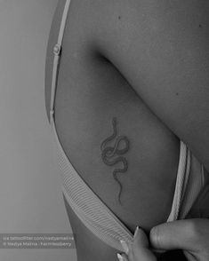 a woman's stomach with a snake tattoo on her left side ribcage