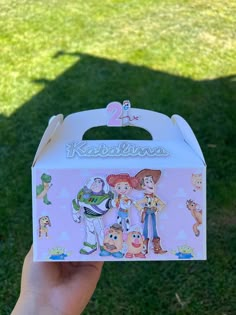 someone is holding up a toy box with the characters from disney and pixama on it