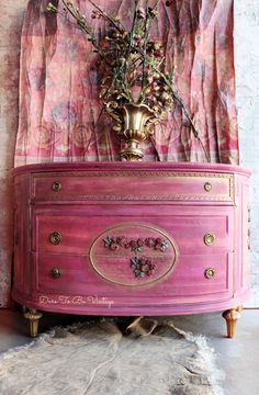 a pink dresser with flowers on top