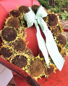 a sunflower wreath on a red chair with a white bow hanging from the front