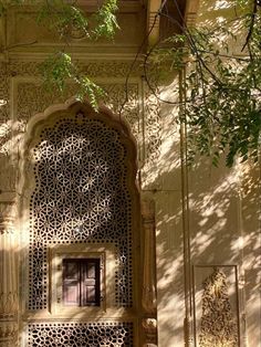 an intricately carved door in the middle of a building with trees growing out of it