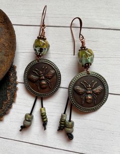 Focus is an amazing pair. The perfect patina Bee Charm rimmed in green along with amazing lamp work beads. Leather dangles add the finishing touch. The earrings are very lightweight, and measure 3 inches long. Copper findings and ear wires. Amazing Lamp, Bee Earrings, Bee Charms, Pretty Jewelry, Oct 1, Copper Earrings, Bead Designs, Pretty Jewellery, Ear Wires