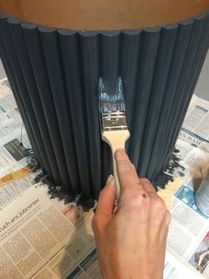 a person using a brush to paint a column